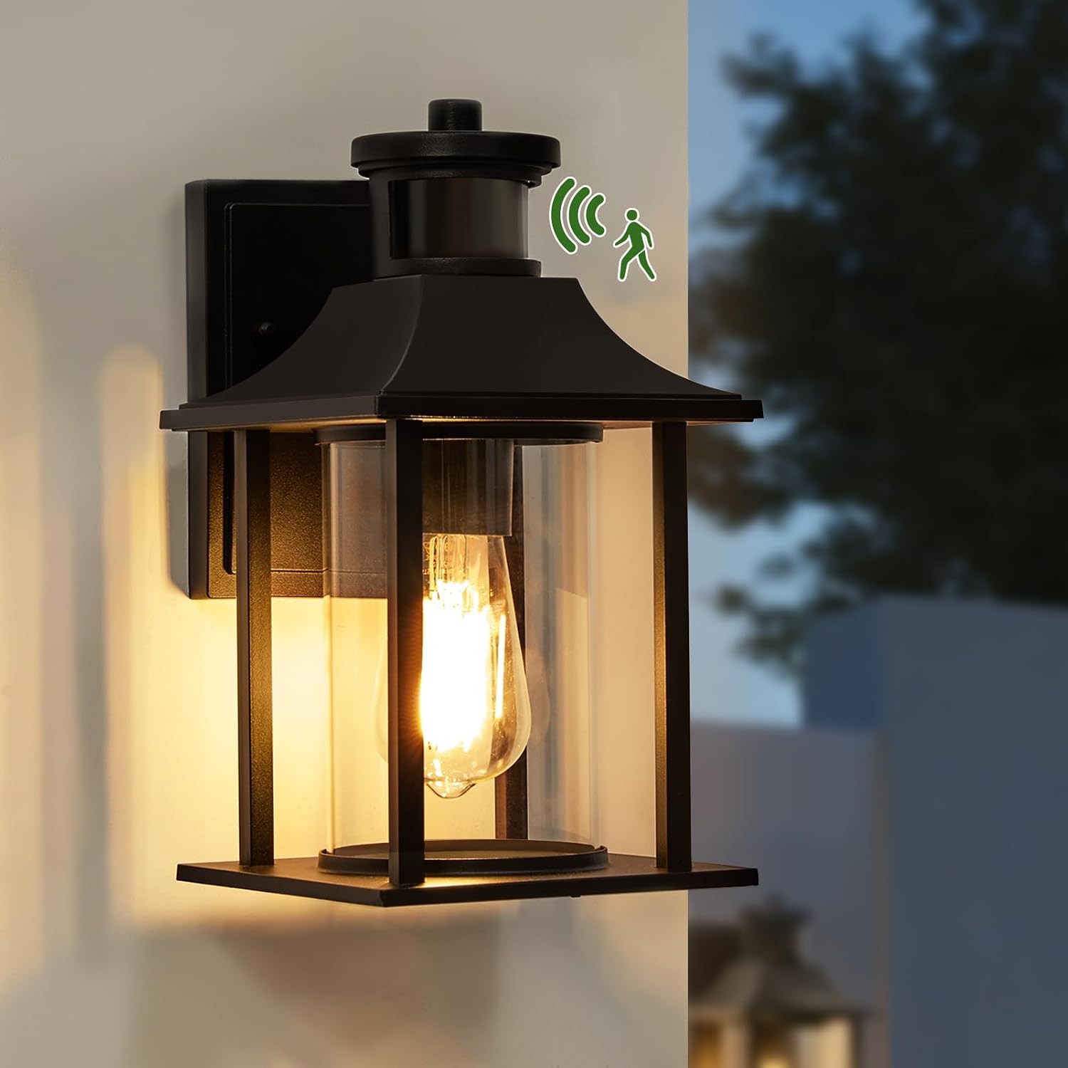 Black LMP outdoor wall lantern with a motion sensor, illuminated at dusk